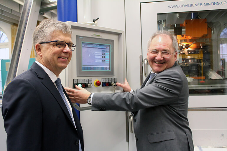 Staatssekretär Peter Hofelich prägt innovative 5-Euro-Münze mit Polymerring 