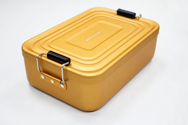 Goldbarren verpackt in goldene Metallbox